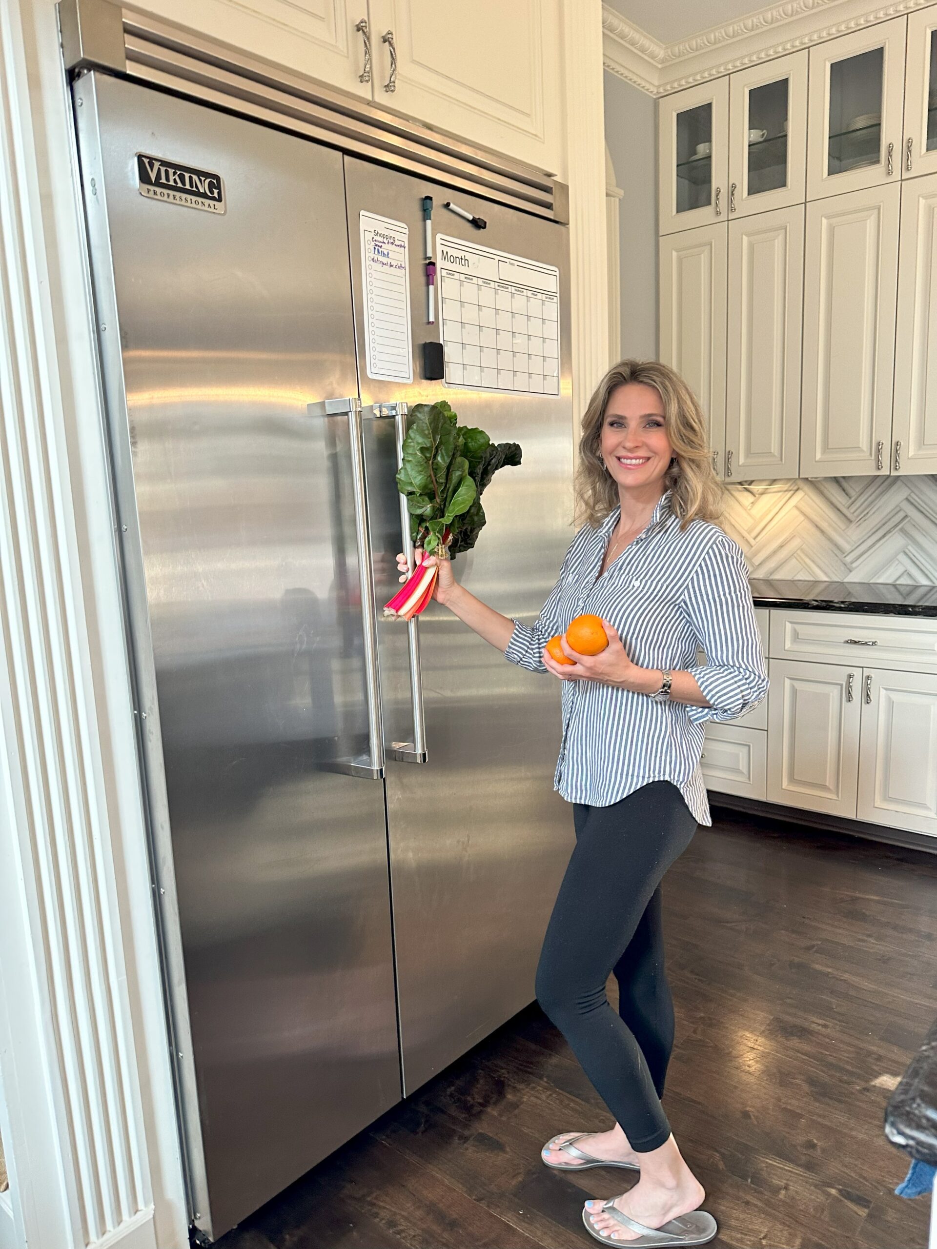 Lauren Freeman Roth standing by the refrigerator with produce in her hands