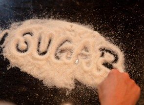 the word "sugar" written in a pile of sugar on a table